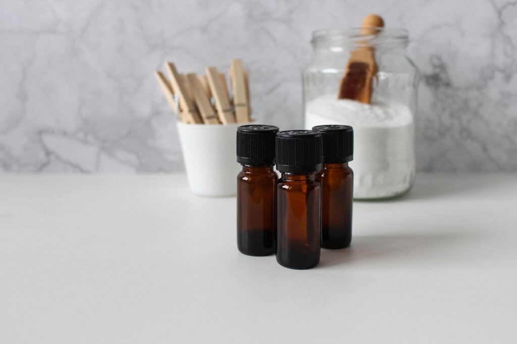 white vinegar and baking soda bottles with folded laundry on clean table