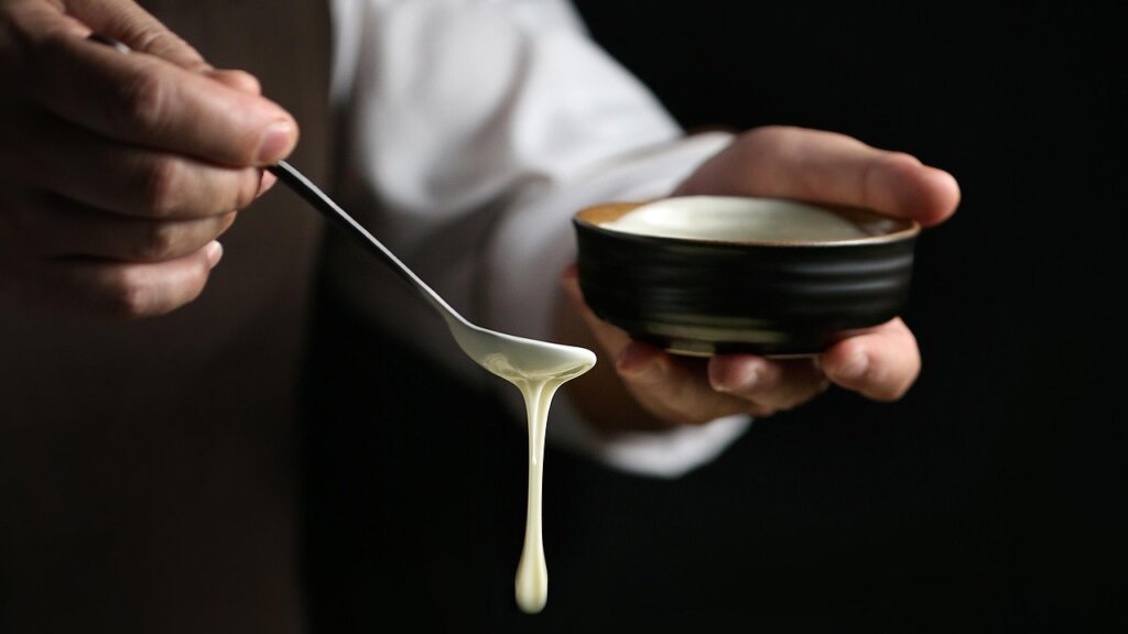 white vinegar pouring into pot after baking soda treatment