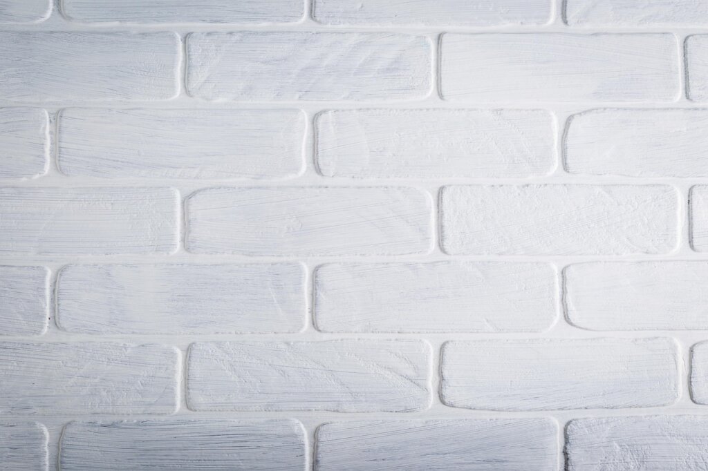 different types of markers and crayons on white wall surface