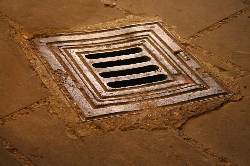 comparison of drain unclogging tools laid out on floor