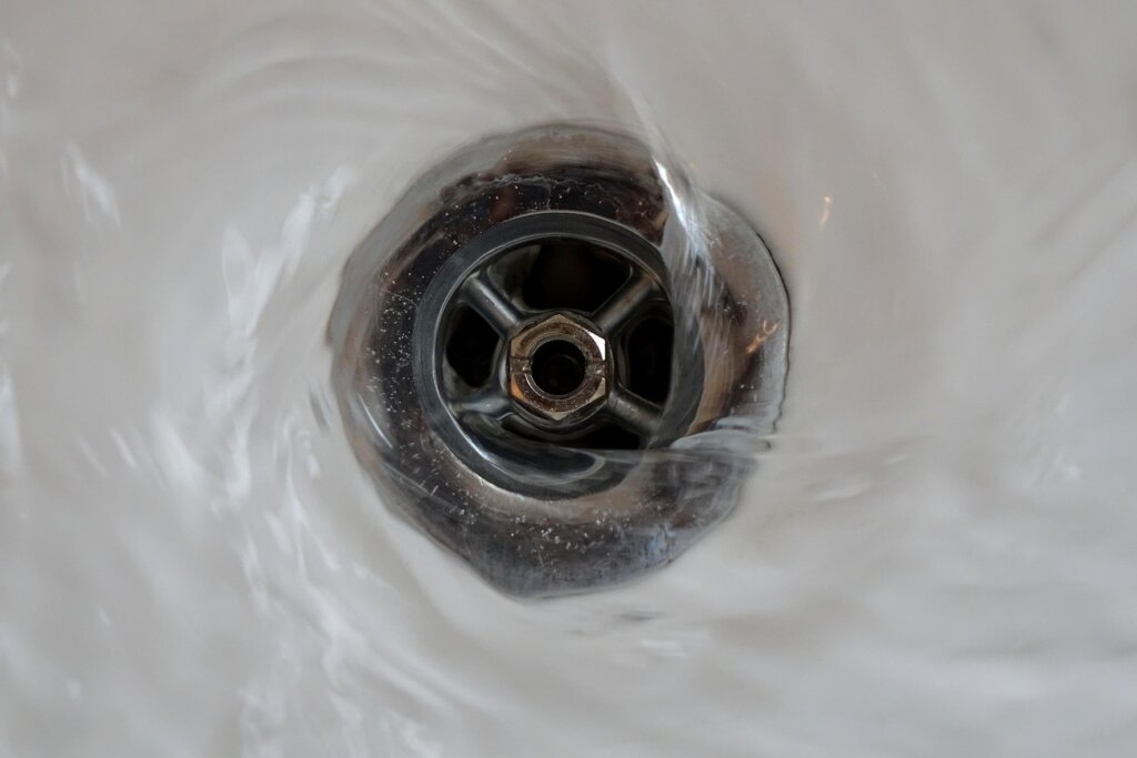 drain snake tool being inserted into sink pipe