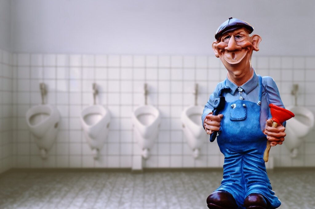 plumber inspecting under sink pipes with tools