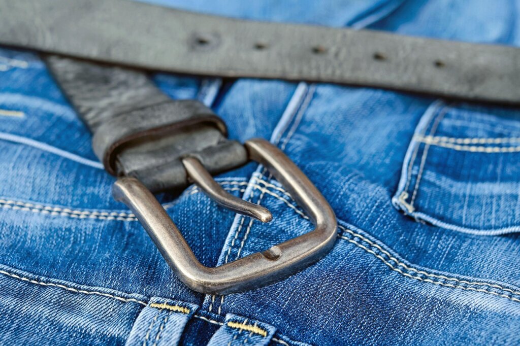 frozen chewing gum being scraped off denim jeans with plastic card