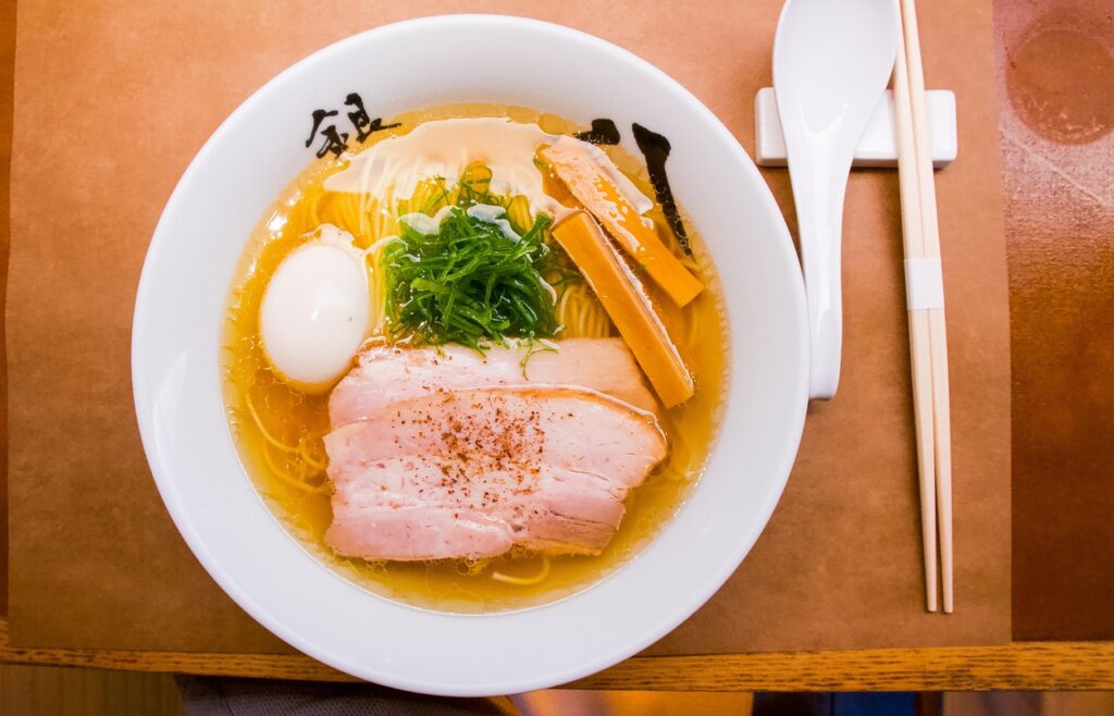 chopsticks gently separating ramen noodles in boiling broth