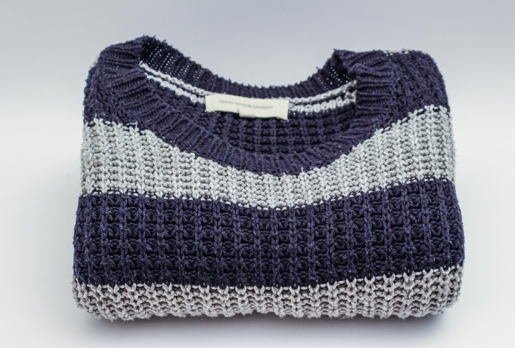 wool sweater laid flat on a white towel to dry