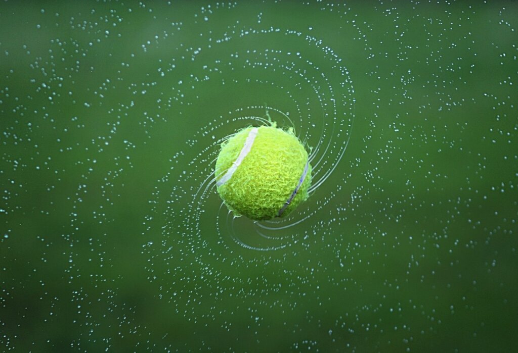 tennis balls inside a clothes dryer with duvet